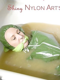 16 of MARA ties and gagges herself in a bath tub cuffs and a cloth gag wearing a super sexy super shiny green rubber rainsuit